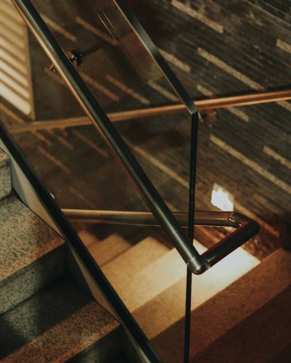 modern indoor staircase with sleek metal and glass handrails.